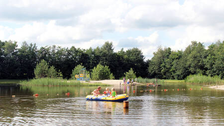 People in a dinghy on recreational lake "De Waterse Koele" at holiday park Molecaten het Landschap
