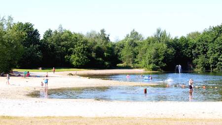 Children on the beach and water of the recreational lake at the Molecaten het Landschap holiday park