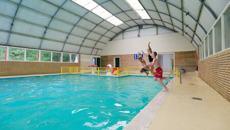 Children jump into the indoor pool of holiday park Molecaten het Landschap