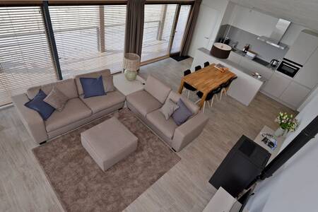 Living room with open kitchen in a holiday home at the Oasisparcs Oasis Punt West holiday park