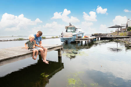 Father and son fishing on a jetty at the Oesterdam Resort holiday park