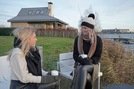 Two women in the garden of a luxury villa at the Oesterdam Resort holiday park