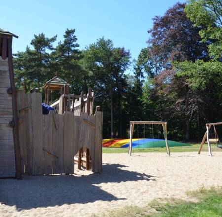 Playground at the Ommerland holiday park with air trampoline, swings and climbing equipment