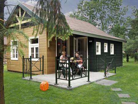 People in the garden of bungalow type "Relaxis" at holiday park Park Molenheide