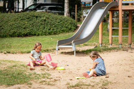 2 Girls play in the sand in a playground at the Petite Suisse holiday park