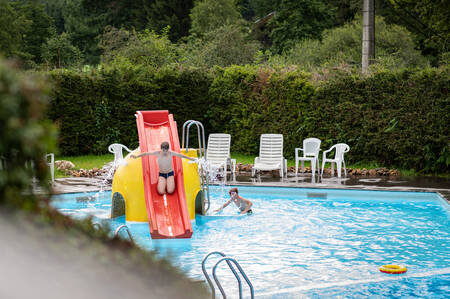 Children slide down the slide in the outdoor pool of the Petite Suisse holiday park