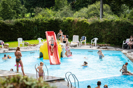 People swimming in the outdoor pool of the Petite Suisse holiday park