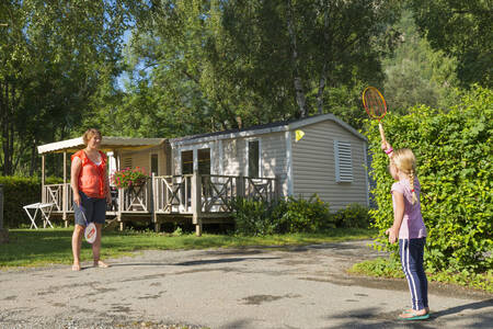 Mother and daughter playing badminton in front of a mobile home at holiday park RCN Belledonne