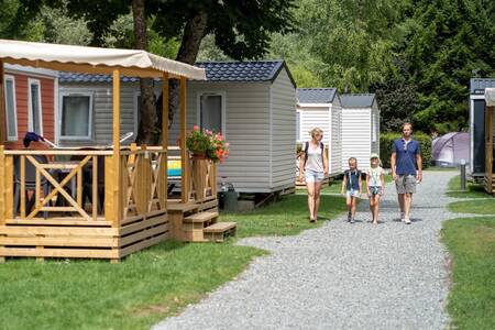 A family walks along a path between mobile homes at the RCN Belledonne holiday park