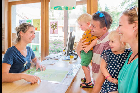 Family at the reception of holiday park RCN Belledonne