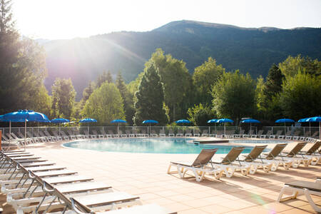Sun loungers around the outdoor swimming pool of holiday park RCN Belledonne