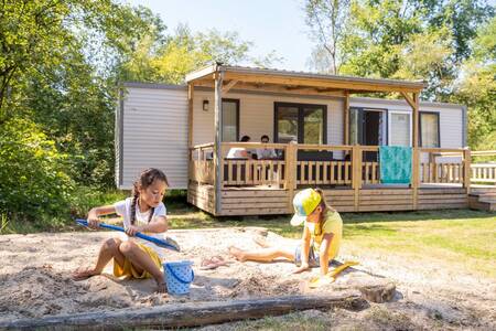 Children play in a sandbox at a chalet at holiday park RCN De Noordster