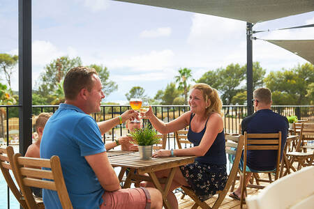 Family is sitting on the terrace of the restaurant at holiday park RCN Domaine de la Noguière