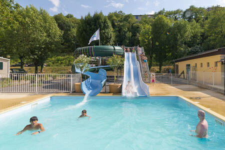 People in the outdoor pool with 2 slides at holiday park RCN La Bastide en Ardèche