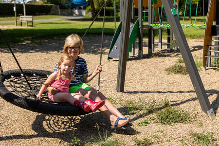 Children on the swing in a playground at holiday park RCN Le Moulin de la Pique