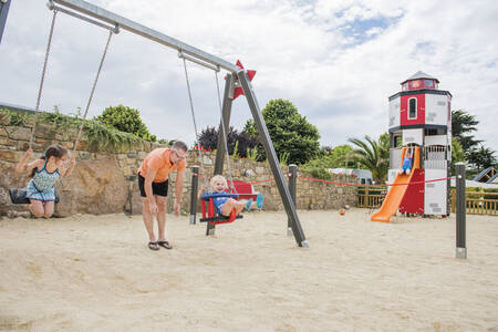 Children on the swing in the playground at holiday park RCN Port l'Epine