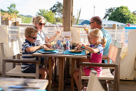 Family eating on the terrace of the restaurant at holiday park RCN Port l'Epine