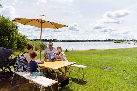 Family at a picnic table at the Veluwemeer at holiday park RCN Zeewolde