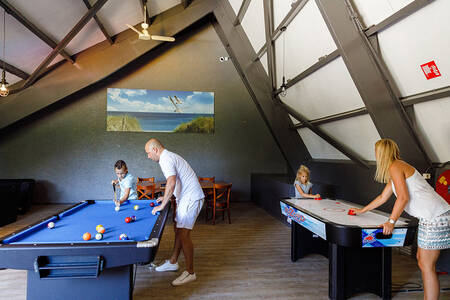 People play in the recreation room at holiday park RCN Zeewolde
