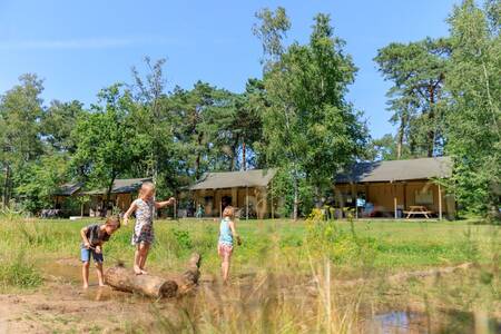 Children play in front of safari tents at holiday park RCN de Flaasbloem