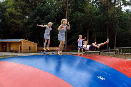 Children jump on the air trampoline in the playground at holiday park RCN de Jagerstee
