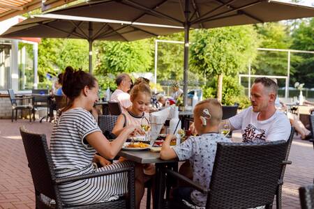 Family eats on the terrace of Brasserie de Jagerstee at holiday park RCN de Jagerstee