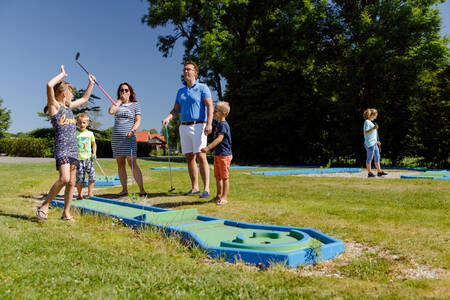 Family playing golf on the miniature golf course of holiday park RCN de Potten