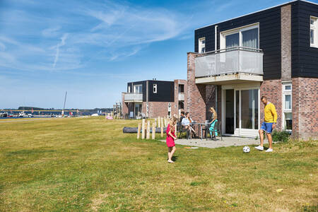 Family on the terrace of an apartment at holiday park RCN de Schotsman