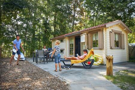 Family in the garden of a chalet at holiday park RCN de Schotsman