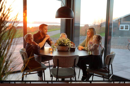 Family at the table in a holiday home at holiday park RCN de Schotsman