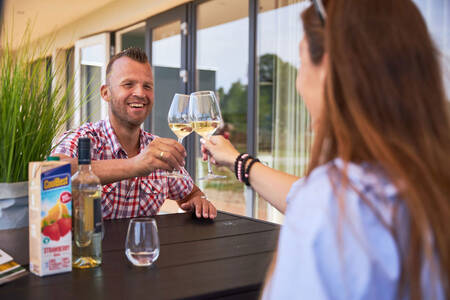 Couple at the table in the garden of a holiday home at holiday park RCN de Schotsman