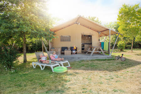 Family relaxes at a safari tent at holiday park RCN la Ferme du Latois