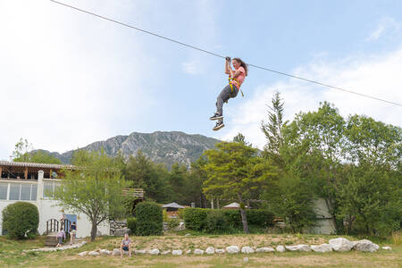 Girl on a zip line in the adventure park at the RCN les Collines de Castellane holiday park
