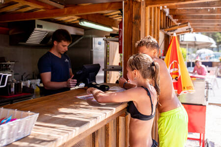 Boy and girl in front of the snack bar of holiday park RCN les Collines de Castellane