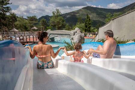 Family slides down a slide in the outdoor pool of holiday park RCN les Collines de Castellane