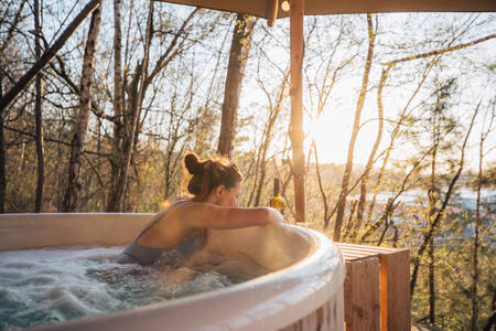 Woman in a hot tub in a tree house at the Warredal Recreational Domain