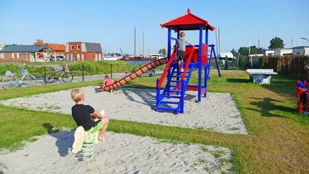 Children play in a playground at holiday park Recreatiepark Tusken de Marren