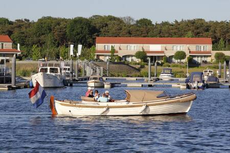 People sail in a sloop in the marina of the Resort Boschmolenplas holiday park