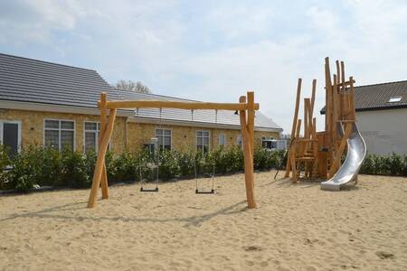 Playground with swings and climbing frame with slide at Resort Mooi Bemelen holiday park