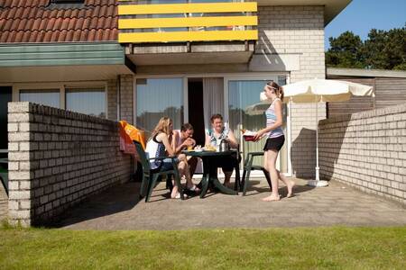 People on the terrace of an apartment at Roompot Apartment complex Bosch en Zee