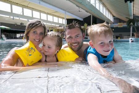 A family is swimming in the indoor pool of the Roompot Beach Resort holiday park