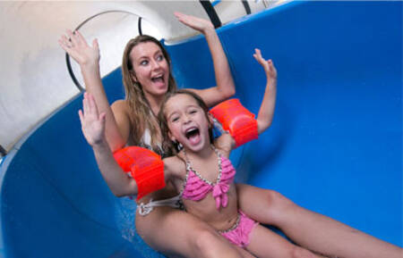 Mother and daughter on the large water slide in the swimming pool of Roompot Beach Resort