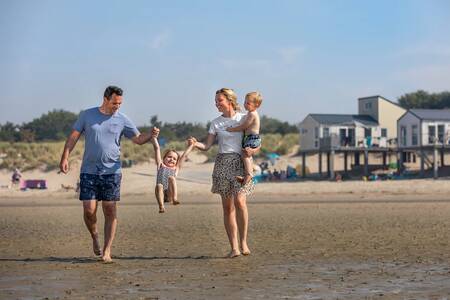 Family on the beach and Beach Houses of the Roompot Beach Resort holiday park