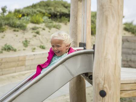 Child on the slide in the playground of Roompot Beach Villas Hoek van Holland