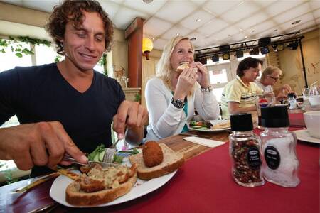 People having lunch at a restaurant at the Roompot Bospark Lunsbergen holiday park