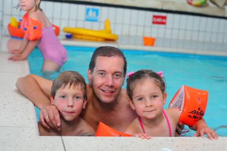 Family swimming in the indoor pool of the Roompot Bospark de Schaapskooi holiday park