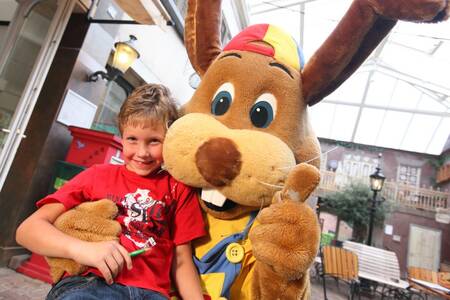 A boy together with Koos rabbit at holiday park Roompot Bospark de Schaapskooi