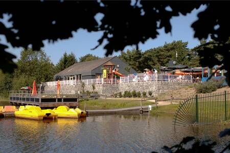 Center building on the lake with pedal boats at holiday park Roompot Bospark 't Wolfsven