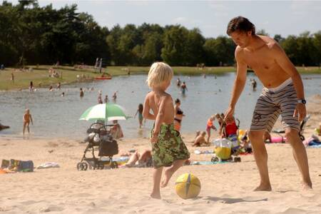 People on the beach of the lake at holiday park Roompot Bospark 't Wolfsven