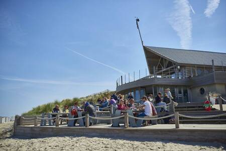 People on the terrace of a beach bar near the Roompot Breeduyn Village holiday park